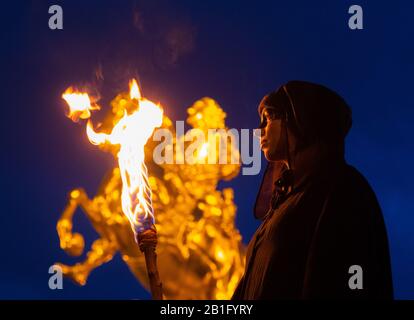 Dresden, Deutschland. Februar 2020. Ein Teilnehmer des jährlichen Karnevalsumzugs "Winterausweisung" steht mit einer Fackel vor dem Goldenen Reiter. Kredit: Robert Michael / dpa-Zentralbild / dpa / Alamy Live News Stockfoto