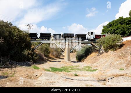 Alter Bergbauzug und Lastwagen auf einer Brücke über ein trockenes Flussbett bei Kalavasos Dorf. Zypern. Stockfoto