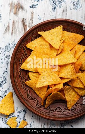 Tortilla-Chips in Keramikplatte von oben aus gesehen, aus nächster Nähe Stockfoto