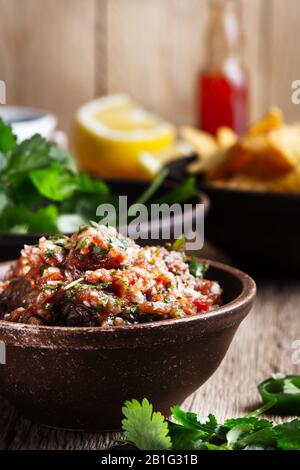 Hausgemachte Salsa- und Tortilla-Pommes, ein beliebter mexikanischer Vorspeisen- Snack auf ländlichem Holztisch, in der Nähe Stockfoto