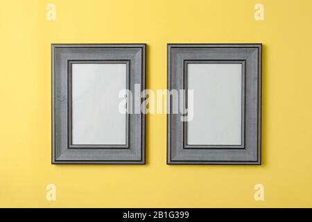 Zwei leere graue Holzfotos auf gelbem Hintergrund Stockfoto