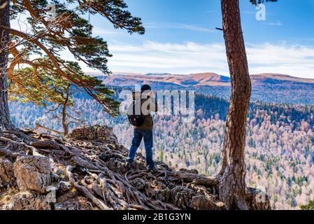 Zurück männlich outdoor Fotograf, Foto von Bergen im Nordkaukasus im Hellen fällt mit seiner Kamera anzeigen Stockfoto