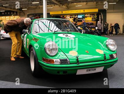 Februar 2020 - London, Großbritannien. Der alte Mann überprüft seltsam ein klassisches Porsche 911-Modell auf der Classic Car Show in London. Stockfoto