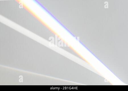 Overlay-Effekt für Fotos und Mockups. Organischer, diagonaler Schatten und Lichtstrahlen aus dem Fenster an einer weißen Wand. Stockfoto