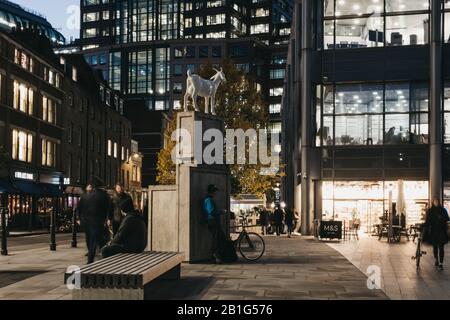 London, Großbritannien - 29. November 2019: I Goat Sculpture von Kenny Hunter in Spitalfields, London, Großbritannien, am Abend, Menschen, die spazieren gehen, Bewegungsunschärfe. Die Statistik Stockfoto