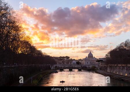 Sonnenuntergang in Rom vor der Basilika di San Pietro, der Brücke von Sant'Angelo und dem Fluss Tevere von der Brücke Umberto I. Stockfoto
