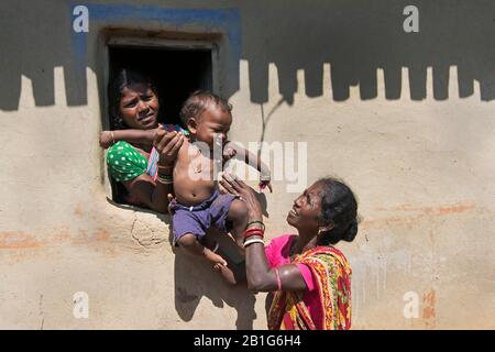 Das Bild der Mutter, die das Kind an die Großmutter im Dorf Purulia, Westbengalen, Indien, Asien weitergibt Stockfoto