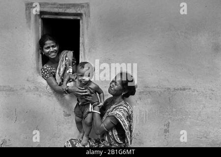 Das Bild der Mutter, die das Kind an die Großmutter im Dorf Purulia, Westbengalen, Indien, Asien weitergibt Stockfoto