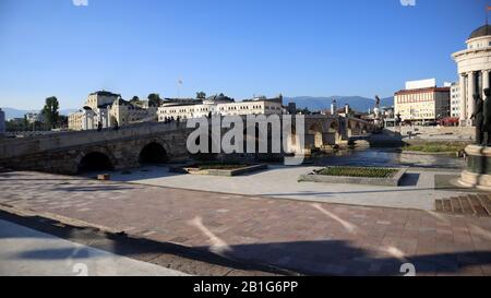 Skopje, Nord-Mazedonien, 27. Juni 2019: Steinbrücke über den Fluss Vardar in der Innenstadt von Skopje in der Nähe des Archäologischen Museums Mazedoniens mit blauem Himmel auf s Stockfoto