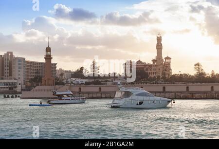 Landschaft mit Montazah-Palast und Leuchtturmturm unter farbenfrohem bewölktem Himmel, Alexandria, Ägypten Stockfoto