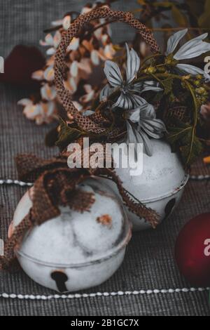 Zwei weiße Glocken zwischen einem osterroten Ei und Frühlingsblumen Stockfoto