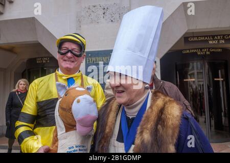 London, Großbritannien. Februar 2020. Die Livery Companies der City of London nehmen an den Inter-Livery Pancake-Rennen in Guildhall Yard Teil, eine Tradition, die die Worshipful Company of Poulterers 2005 begonnen hatte und die Charity des Lord Mayor unterstützte. Poulterers liefern Eier für die Pfannkuchen, Uhrmacher geben Zeit für die Rennen, Gunnmakers feuern eine Startpistole und Fruiters stellen die Zitronen zur Verfügung. Neben den Wettbewerben für Meister und Mitglieder der Firmen gibt es auch eine ausgefallene Kleiderklasse, die einige interessante Beiträge zu den Lügengesellschaften und der Wohltätigkeitsorganisation enthält. Peter Marshall/Alamy Live News Stockfoto