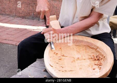 Holzschnitzerei. Professioneller Zimmermann schnitzt Holzhandwerk mit einem Holzbearbeitungswerkzeug, Hände nah oben. Zimmerei und Handwerkskunst. Stockfoto