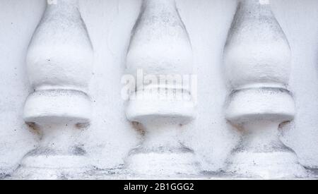 Klassische weiße Balustrade isoliert auf Betonwandzaun. Betonsteg als Hintergrund. Stockfoto