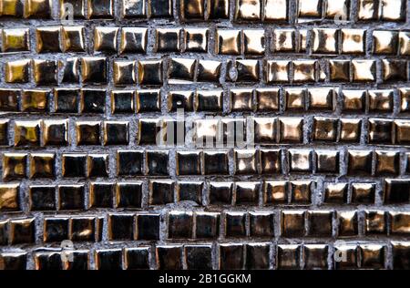 Goldene Wandtextur aus Mosaikfliesen. Hintergrundbild. Textur kleiner Mosaikfliesen. Stockfoto