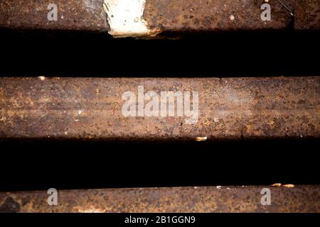 Nahaufnahme des Metallgitters des Abwasserkanals, Muster des quadratischen Gitters, Abdeckung Des Manlochabflusses in Betonstraße. Stockfoto