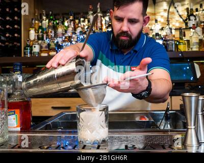 In dieser Abbildung macht ein Barkeeper einen Bamboleo-Cocktail in der Rooster Grill Bar. Stockfoto