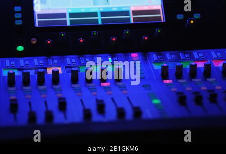Audiomixer in blauen Lampen Fader und Touchscreen in einem Theater Stockfoto