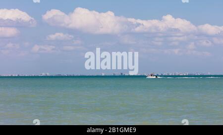 Skyline von Fort Myers von Sanibel Island aus auf dem Wasser mit einem Boot, Florida, USA Stockfoto