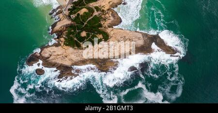 Arpoador [Harpooner] Felsformation an der Küste von Rio de Janeiro in der Nachbarschaft von Ipanema. Draufsicht mit krachenden Meereswellen Stockfoto