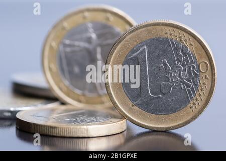 Alte eine Euro-Münze steht auf dem Schreibtisch in der Nähe des Goldgeldpfahls. Stockfoto