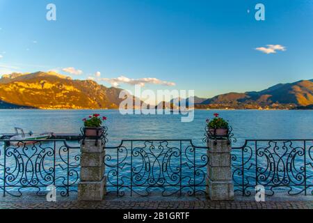 Ein alter Eisenzaun am Comer See mit Bergen und blauem Himmel Stockfoto