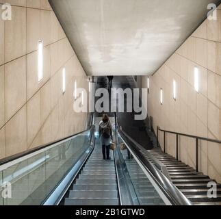 Rückansicht der einsamen Frau steigen die Rolltreppe der U-Bahn-Treppe in der schönen Metrostation hinunter Stockfoto