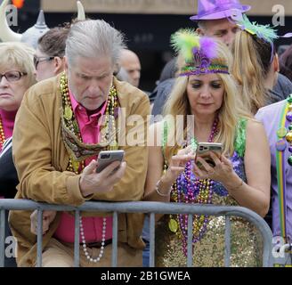 New Orleans, Vereinigte Staaten. Februar 2020. Mardi Gras Enthüller überprüfen ihre Telefone, während sie am Dienstag, den 25. Februar 2020, auf einer Parade in New Orleans warten. Foto von AJ Sisco/UPI Credit: UPI/Alamy Live News Stockfoto