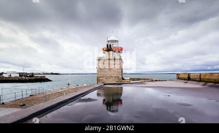 Howth Lighthouse reflektierte sich im Wasser. Bewölktes Wetter Howth Harbour, Dublin, Irland Stockfoto