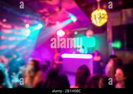 Verwackelte Menschen im Disco-Club mit bunten Laserlichtern im Hintergrund - Unschärfe-Bild - Konzept des Nachtlebens mit Musikunterhaltung - Original Stockfoto