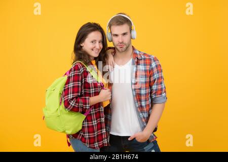 Portrait attraktiver junger Studenten Paar. Fröhliche Frau mit Rucksack. Kerl in Kopfhörern. Online-Bildungskonzept. Zurück zur Schule. Ein Paar Studenten im Ausland. Studium im Ausland Konzept. Auf dem Campus. Stockfoto