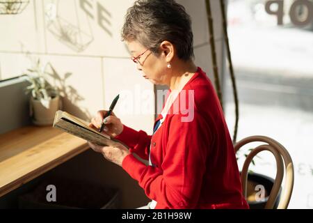 Seniorin nimmt Notiz Stockfoto