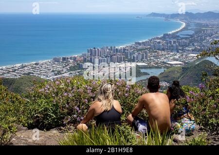 Die Leute genießen den Blick vom beliebten Wander-Aussichtspunkt Pedra Bonita mit Blick auf die Barra da Tijuca Nachbarschaft mit bunten Blumen rund um Stockfoto