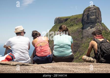 Die Leute, die von hinten gesehen werden, genießen den Blick vom Aussichtspunkt Pedra Bonita mit dem Gavea Felsen im Hintergrund in Rio de Janeiro, Brasilien Stockfoto