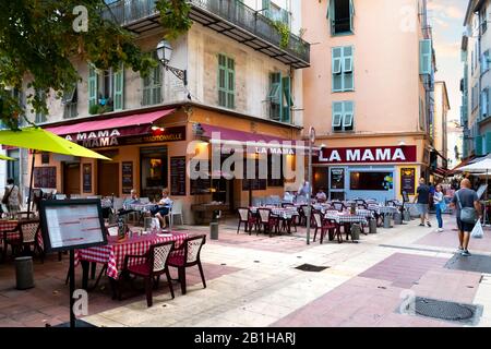 Ein italienisches Straßencafé mit Tischen auf der Terrasse in der Altstadt von Vieux in Nizza, Frankreich, an der französischen Riviera. Stockfoto