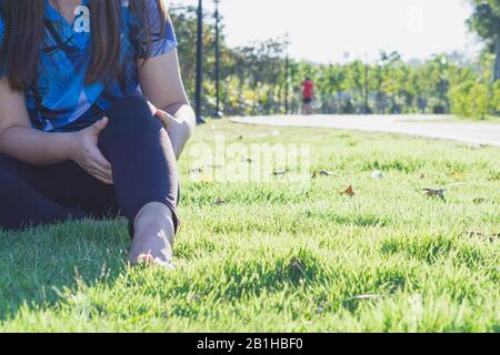 Knieverletzungen. Young Sport Frau knie Holding mit ihren Händen in den Schmerz nach Leiden Muskelverletzungen während eines laufenden Training im Park. Healthcare eine Stockfoto