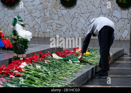 Menschen, die in der Gedenkfeier russischer Soldaten am Siegesfeiertag der Sowjetzeit Blumen auf dem Granit anbieten (legen). Stockfoto