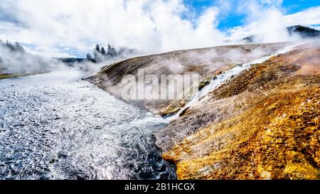 Heißes Wasser aus dem Excelsior Geyser Crater, das in den Firehole River im Yellowstone National Park, Wyoming, United Sates fließt Stockfoto