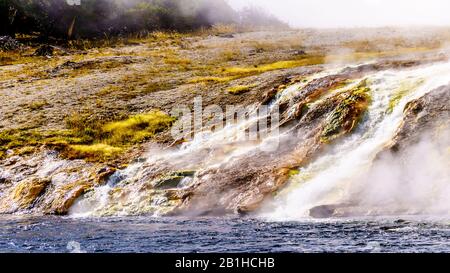 Heißes Wasser aus dem Excelsior Geyser Crater, das in den Firehole River im Yellowstone National Park, Wyoming, United Sates fließt Stockfoto