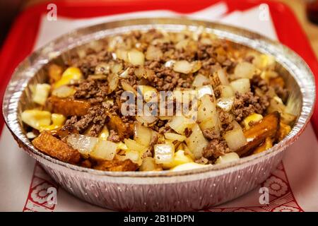 Berühmte kanadische Küche, bekannt als Poutine mit handgeschnittenen Pommes frites und Käsegewalten, die mit Zwiebeln, gemahlenem Rindfleisch und brauner Gravy bestockt sind. Das Gericht Stockfoto