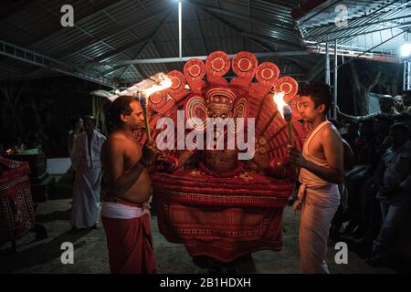 Theyyam Performer tanzt als lebendiger gott eine beliebte rituelle Form der Anbetung in Nord-Kerala, in der Nähe von Kannur, Indien. Stockfoto