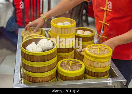 Kellnerin, die im chinesischen Restaurant gedämpfte Dimmsum auf dem Wagen serviert Stockfoto