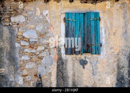 Blaue hölzerne Klappe, mit abblätternder Farbe auf einem Gebäude in Korfu Stadt, Griechenland, Ionisches Meer, Reise, Abenteuer, Urlaub, altes Gebäude Stockfoto