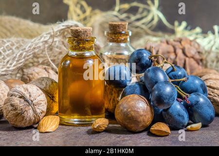 Kosmetisches und medizinisches Macadamienöl, auf braunem Grund, Nahaufnahme: Öl für Frauen, Kosmetologie, Behandlung. Natürliche Seren. Stockfoto