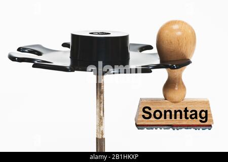 In einer Stempelablage hängt ein Stempel mit der Aufschrift Sonntag (Sonntag) Stockfoto