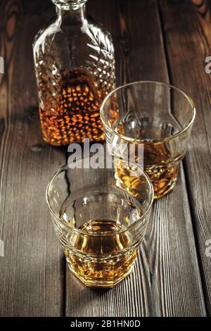 Whiskey Glas und Flasche auf dem alten Holztisch Stockfoto