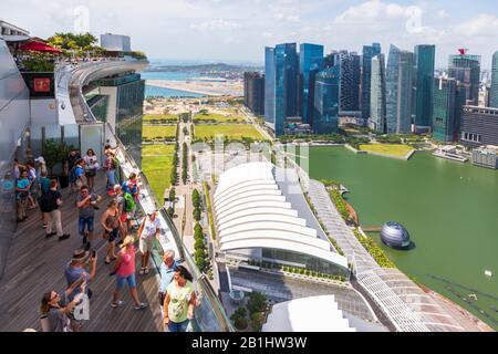 Touristen auf der Aussichtsplattform des Hotels Marina Bay Sands mit Blick auf die Marina Bay zum Geschäftsviertel von Singapur, Asien Stockfoto