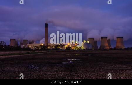 Drax, North Yorkshire. Der Abend fällt auf das ländliche Dorf Drax mit den funkelnden Lichtern einer örtlichen Kraftstation und Wasserdampf, die von TH aussendet Stockfoto