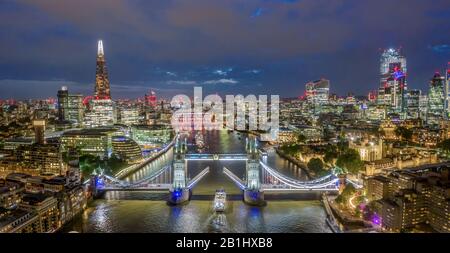 Luftbild der Tower Bridge London bei Nacht. Drohnenfoto von der Themse, einschließlich Shard, Gherkin und Rathaus Stockfoto