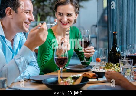 Leute, die Spaß haben, in einem gehobenen Restaurant zu essen und zu trinken Stockfoto